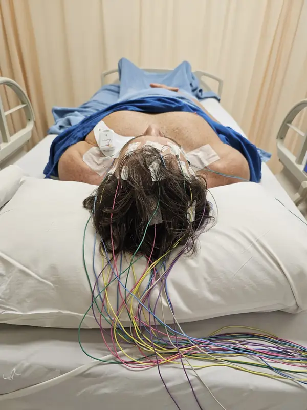 Peter lying down wearing an EEG cap during a brain check
