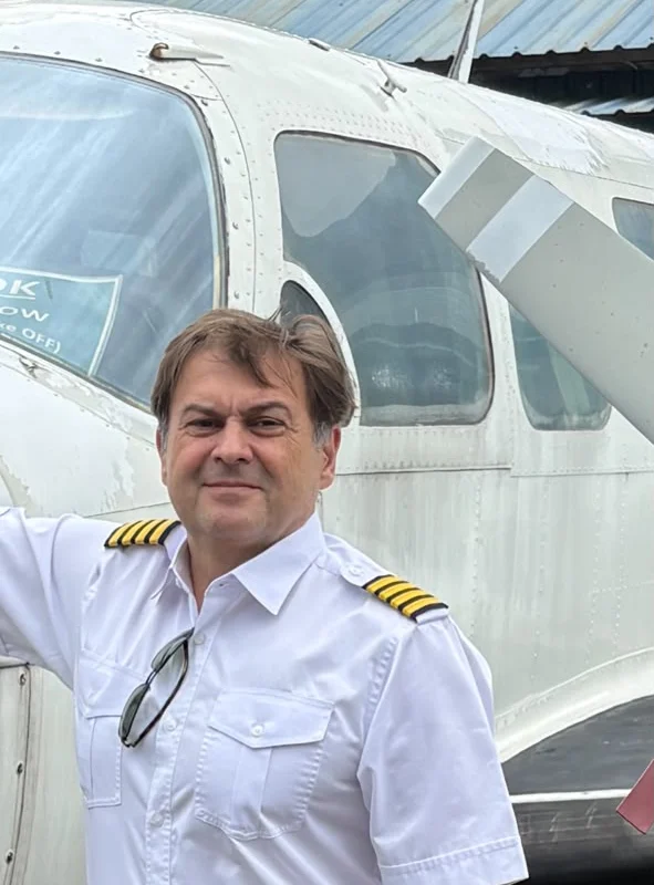 Peter in his captain's uniform beside a light aircraft at Sultan Abdul Aziz Shah Airport