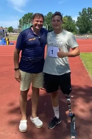 Peter with a para-athlete with a running prosthesis on a running track